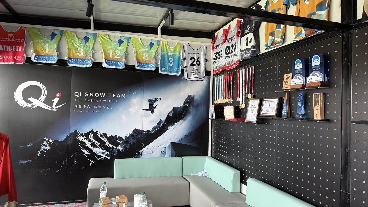 Qi Snow Team 训练空间的品牌墙与奖杯陈列实拍照片